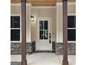 Charming front entrance with a stylish white door, stone accents, and dark wood columns at 6093 Wayfarer Dr, Villa Rica, GA 30180