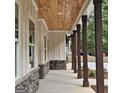 Inviting porch featuring exposed wood ceiling, stone accents, and classic architectural details at 6093 Wayfarer Dr, Villa Rica, GA 30180