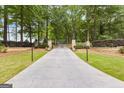Long paved driveway lined with trees and manicured landscaping leading to property at 290 Weldon Rd, Fayetteville, GA 30215