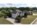 An aerial view of a two-story home with an attached garage, driveway, and lush landscaping at 313 Masters Club Blvd, Hampton, GA 30228