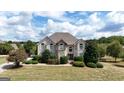 Beautiful two-story home featuring a well-manicured lawn and nicely landscaped front yard at 313 Masters Club Blvd, Hampton, GA 30228
