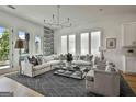 Bright living room featuring a white sofa, patterned rug, ample natural light, and stylish decor accents at 145 Kelmscott Ln, Fayetteville, GA 30214