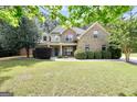 Inviting two-story home showcasing a lush green lawn, mature trees, and a cozy covered entry at 204 Carmell Ct, Mcdonough, GA 30252