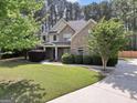 Beautiful two-story home boasting a well-kept lawn, mature trees, and a paved driveway at 204 Carmell Ct, Mcdonough, GA 30252