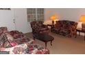 Cozy living room featuring matching floral sofas and chairs offering a comfortable gathering space at 1320 Labelle St, Jonesboro, GA 30238