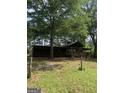 A rustic home featuring a large wrap-around porch nestled in a wooded area at 3255 Flat Shoals Sw Rd, Conyers, GA 30094