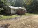 View of charming home with metal roof, covered front porch and surrounded by trees at 5552 Smithfield Rd, Bowdon, GA 30108