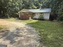 A charming home featuring a metal roof, covered front porch and gravel driveway at 5552 Smithfield Rd, Bowdon, GA 30108