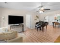 Open-concept living room with a TV, piano, and view to the kitchen and dining area at 45 Plantation Ln, Locust Grove, GA 30248
