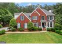 Lovely two-story brick home with a well-kept lawn, symmetrical design, and inviting curb appeal in a serene setting at 495 Stonehaven Dr, Fayetteville, GA 30215