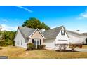 Well-maintained home featuring a brick facade, white siding, and a manicured lawn on a clear day at 1716 Anniston Dr, Mcdonough, GA 30253