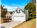 Charming two-story home with a well-maintained lawn, white siding, and a two-car garage on a sunny day at 1716 Anniston Dr, Mcdonough, GA 30253