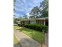 Attractive single-story brick home featuring a walkway, green lawn and tidy shrubbery at 9163 Fair Sw St, Covington, GA 30014