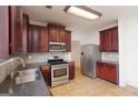 Well-lit kitchen featuring dark cabinets, stainless steel appliances and tile flooring at 1281 Heartwood Ave, Mcdonough, GA 30253