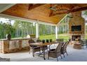 Well-appointed outdoor patio with a built-in grill, fireplace, and dining area at 211 Hogan Coweta Rd, Hogansville, GA 30230