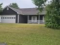 Traditional one-story home with a spacious front yard, garage, and covered porch at 10 Nicole Ct, Covington, GA 30016