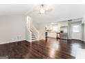 Open-concept living room and kitchen with hardwood floors, white cabinets, and stainless steel appliances at 1590 Sw Cherry Hill Ln, Conyers, GA 30094