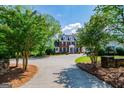 Beautiful two-story home with a circular driveway, surrounded by lush landscaping and mature trees at 1745 Stripling Chapel Rd, Carrollton, GA 30116