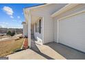 This is the side view showing the garage door, the front porch, and light colored siding at 6324 Amberly Rd, Rex, GA 30273