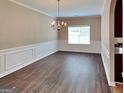 Traditional dining room with elegant chandelier, wainscoting, and wood floors at 4140 Butternut Pl, South Fulton, GA 30349