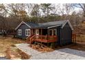 Beautiful exterior view of a home with a wooden porch and surrounding gravel landscaping near a pond at 79 Turner Dr, Mcdonough, GA 30252