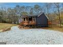 Beautiful exterior view of a home with a wooden porch and surrounding gravel landscaping near a pond at 79 Turner Dr, Mcdonough, GA 30252