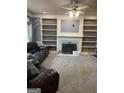 Open living room features a fireplace, built-in shelving, and neutral carpet at 171 Galesburg Dr, Lawrenceville, GA 30044