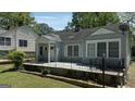 Street view of light blue single-story home with white trim, large porch and mature trees at 1774 Campbellton Rd, Atlanta, GA 30311