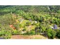 Wide aerial shot showcasing a home with a pool and a vast expanse of lush, mature trees and winding driveways at 550 Davis Rd, Fayetteville, GA 30215