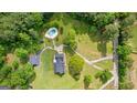 A sprawling estate with a pristine pool area, lush landscaping, and a winding driveway showcases luxury living at 550 Davis Rd, Fayetteville, GA 30215