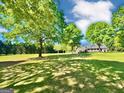 Large green lawn with home and covered porch in background at 1040 Rock Creek Rd, Social Circle, GA 30025