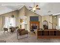 Bright living room featuring a brick fireplace, vaulted ceilings with fan, and contemporary furnishings at 402 Sherrels Frd, Peachtree City, GA 30269