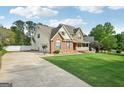 Inviting two-story home with a spacious driveway, brick accents, a covered porch, and a well-maintained lawn at 612 Longer Dr, Peachtree City, GA 30269