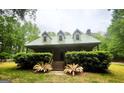 Charming home with a green metal roof and nicely landscaped front yard at 695 Frog Rd, Locust Grove, GA 30248