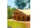 Two-story home under construction shows exposed wood frame with some windows, surrounded by lush trees and greenery at 107 Oak Rd, Locust Grove, GA 30248