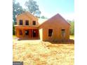 Wood frame of a two-story house under construction with covered porch, on a sunny day with natural surroundings at 107 Oak Rd, Locust Grove, GA 30248
