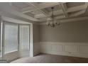 Dining room with coffered ceiling, wainscoting, neutral paint, large windows offering ample natural light at 1124 Pebble Creek Ln, Locust Grove, GA 30248