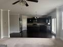 Open kitchen features dark cabinetry, stainless steel appliances, granite countertops and large center island at 1124 Pebble Creek Ln, Locust Grove, GA 30248
