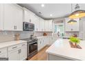 Bright kitchen with white cabinets, stainless steel appliances, quartz countertops, and tiled backsplash at 19 Mediterranean Ave # 506, Sharpsburg, GA 30277