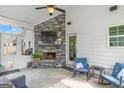 Cozy covered patio featuring a stone fireplace, TV, comfortable seating, and stylish decor at 19 Mediterranean Ave # 506, Sharpsburg, GA 30277