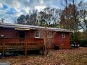 View of back brick home with deck surrounded by trees in the backyard at 309 Cornish Mountain Rd, Covington, GA 30014