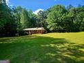 Scenic exterior of a brick home with a lush green lawn surrounded by mature trees at 309 Cornish Mountain Rd, Covington, GA 30014