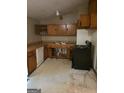 Functional kitchen with wooden cabinets, standard appliances, and lots of potential at 4298 Brookside Dr, Forest Park, GA 30297