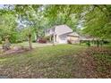 View of a two-story home featuring yellow siding, a paved driveway, and well-kept landscaping at 131 Sweetgum Rd, Peachtree City, GA 30269
