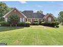 Lovely brick home featuring a beautifully maintained lawn and mature landscaping at 70 Lake Charles Xing, Covington, GA 30016