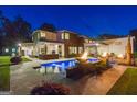 A modern home featuring a luxurious pool, fire bowls, and beautifully landscaped backyard at dusk at 159 Sims Rd, Tyrone, GA 30290