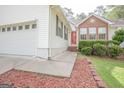 Inviting front entrance with red door, brick accents and meticulous landscaping along the front of the home at 2180 Briarwood Ct, Villa Rica, GA 30180
