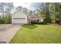 Charming one-story home with a well-manicured lawn and a two-car garage providing ample parking space at 2180 Briarwood Ct, Villa Rica, GA 30180