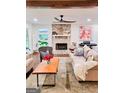Inviting living room featuring a stone fireplace, hardwood floors, and comfortable seating, perfect for relaxation at 508 Caxton Ct, Peachtree City, GA 30269