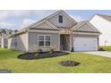Charming home with a two-car garage, complemented by green grass and beautiful landscape at 281 Limestone Circle, Conyers, GA 30013